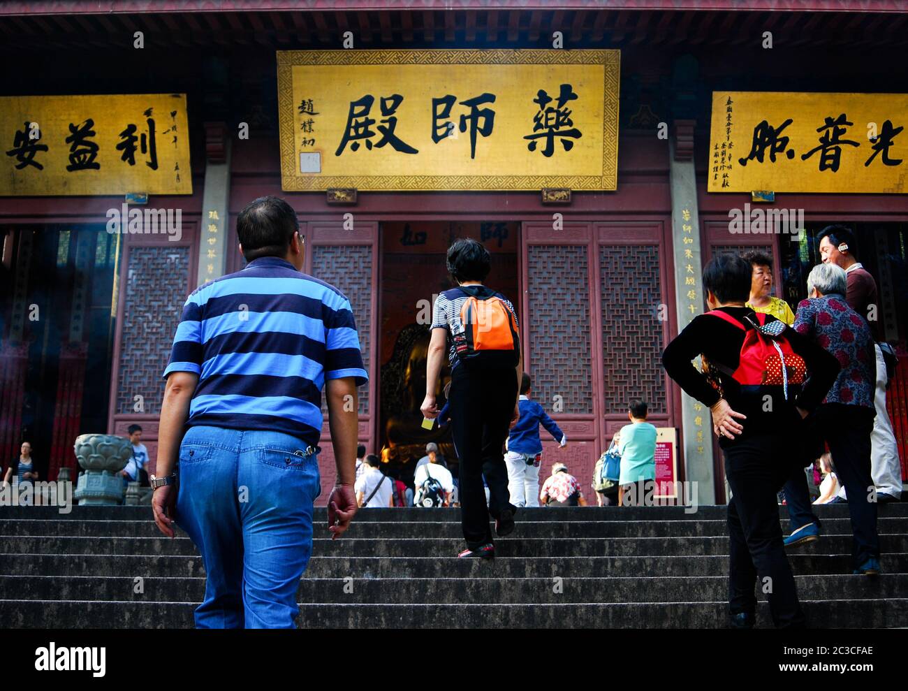 Les touristes chinois se prominaient dans les escaliers jusqu'à la porte du temple bouddhiste avec des signes de personnages chinois à l'entrée. Banque D'Images