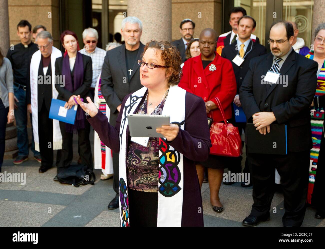 Austin, Texas USA, février 2013: Femme ministre, lisant une prière sur iPad tablette ordinateur, et d'autres membres du clergé exhortent les législateurs du Texas à rétablir le financement pour la planification familiale et les services de contrôle des naissances pour les femmes à faible revenu lors d'une conférence de presse au Texas Capitol. La foi en l'action du Texas et le Texas Freedom Network sont des organisations non partisanes et populaires de dirigeants religieux et communautaires. ©MKC/Bob Daemmrich Photography, Inc Banque D'Images