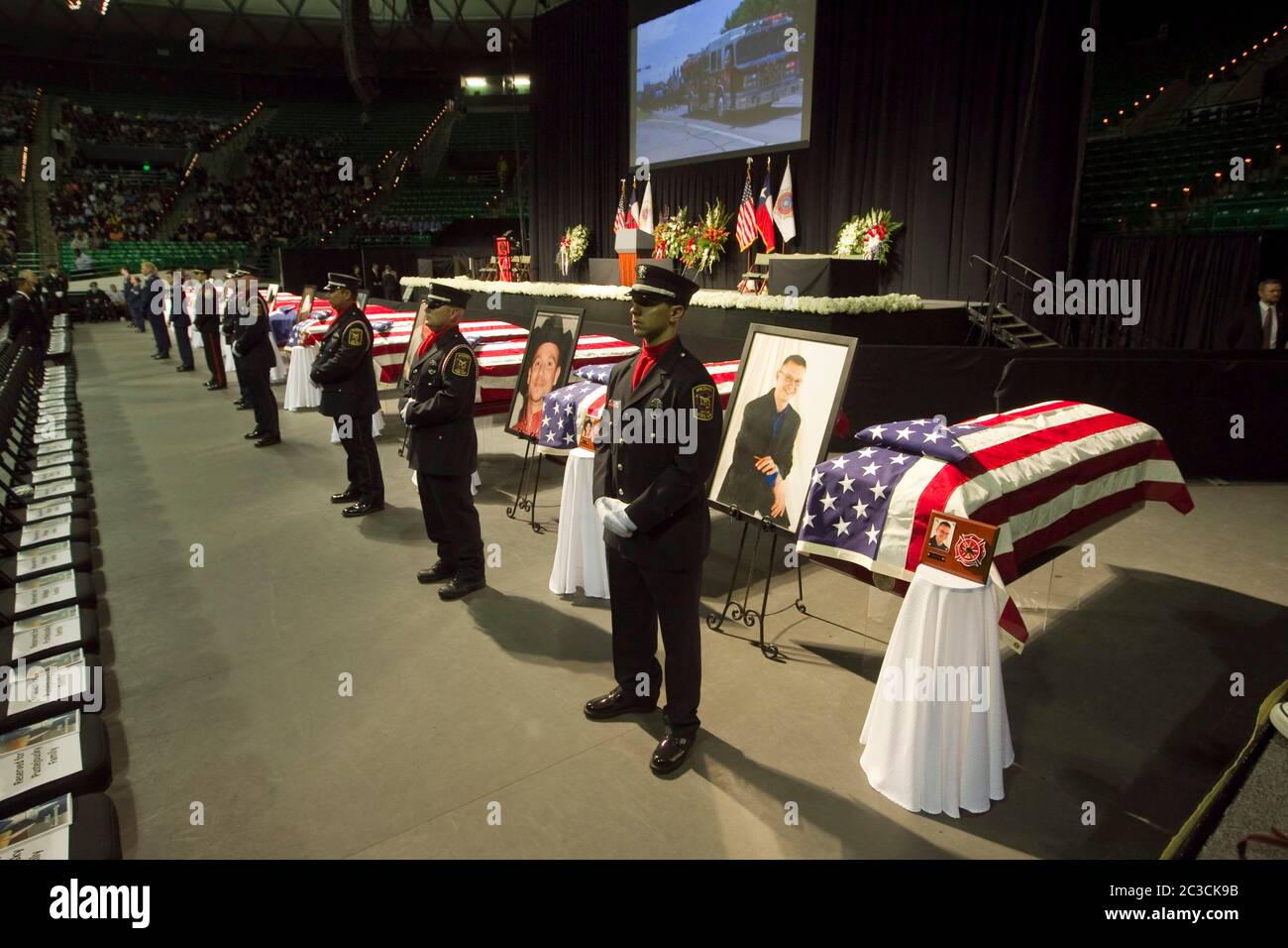 25 avril 2013 Waco, Texas États-Unis : les membres de la garde d'honneur se tiennent devant les cercueils drapés par le drapeau tandis que des milliers de mouneurs assistent à un mémorial pour les pompiers tués dans l'Ouest, Texas, explosion d'usine d'engrais sur 17 avril. Douze des 15 personnes tuées étaient des premiers intervenants. ©Marjorie Kamys Cotera/Daemmrich Photographie Banque D'Images