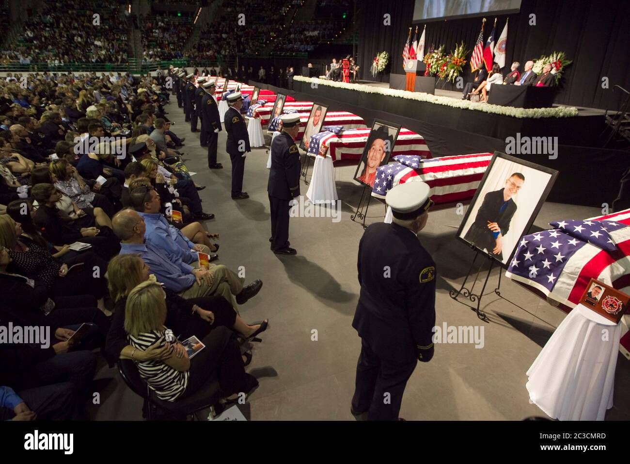 25 avril 2013 Waco, Texas États-Unis : les membres de la garde d'honneur se tiennent devant les cercueils drapés par le drapeau tandis que des milliers de mouneurs assistent à un mémorial pour les pompiers tués dans l'Ouest, Texas, explosion d'usine d'engrais sur 17 avril. Douze des 15 personnes tuées étaient des premiers intervenants. ©Marjorie Kamys Cotera/Daemmrich Photographie Banque D'Images