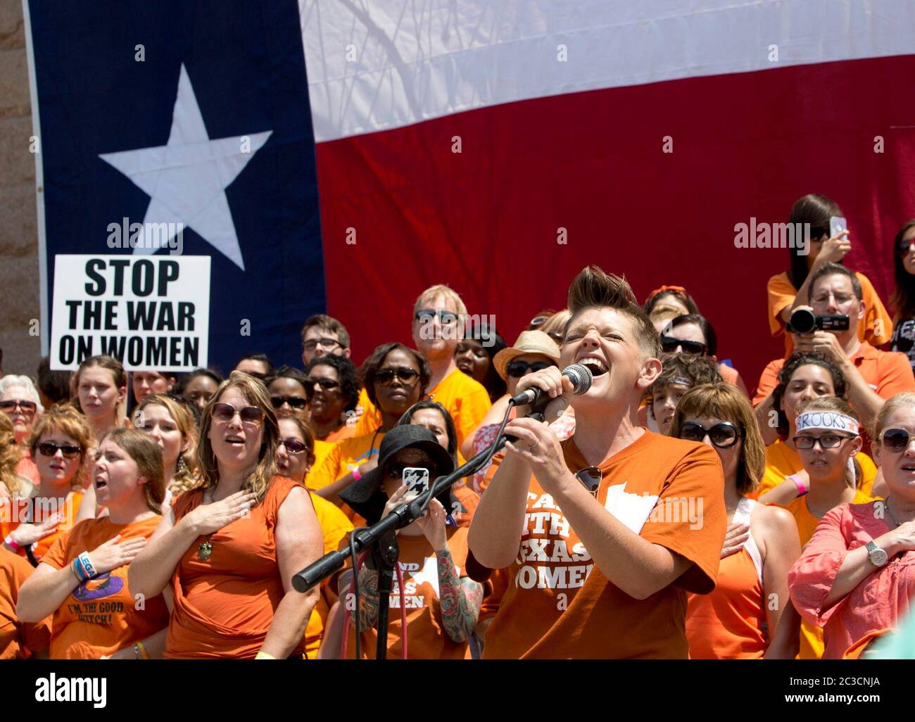 1 juillet 2013 Austin, Texas États-Unis : Une jeune femme portant un maillot Stand with Texas Women chante l'hymne national devant une foule de partisans du choix lors d'un rassemblement devant le Capitole du Texas avant le début d'une deuxième session législative spéciale appelée à examiner des limites controversées sur l'accès des femmes à l'avortement. ©Bob Daemmrich Banque D'Images