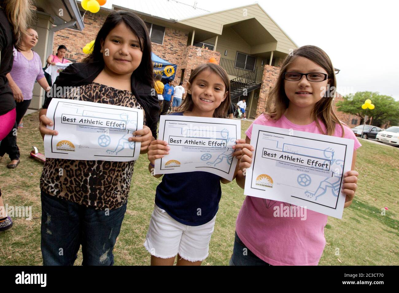 Austin Texas Etats-Unis, 12 avril 2014: Les filles d'âge scolaire montrent leurs certificats pour participer à une foire de santé et de forme physique organisée par une organisation à but non lucratif pour enseigner aux parents et aux enfants comment faire de l'exercice et bien manger. L'événement comprenait des courses, des jeux et des démonstrations par des experts en fitness. ©Marjorie Kamys Cotera/Daemmrich Photographie Banque D'Images
