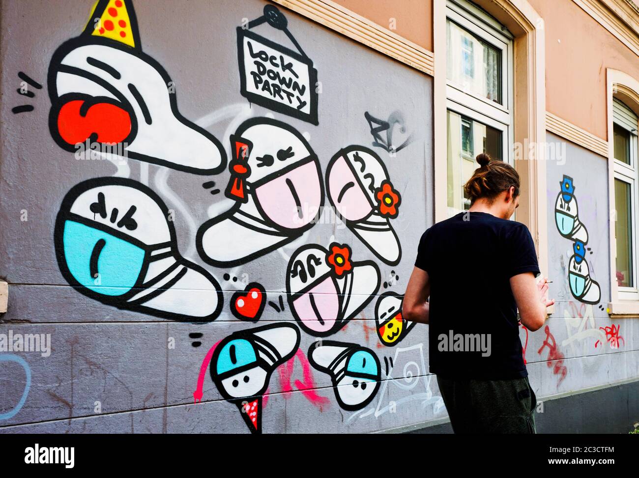 Dortmund, Allemagne, 19 juin 2020 : vers de masque. Depuis le déclenchement de la crise de la couronne en mars 2020, de petits graffiti de virus de la couronne avec un masque buccal créé par un pulvérisateur inconnu peuvent être vus sur de nombreux murs de maison à Dortmund. --- Dortmund, 19.06.2020: Maskenwürmchen. Seit Ausbruch der Corona-Krise im März 2020 sind kleine Coronairen-graffite mit Mundschutz eines unbekannten Sprayers an vielen Hauswänden in Dortmund zu sehen. Banque D'Images