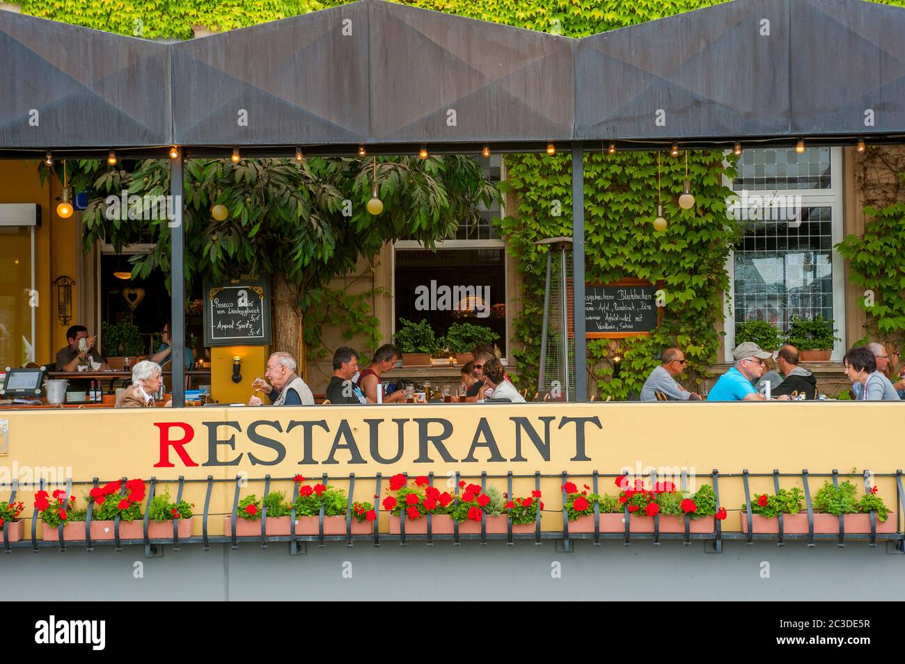 Les gens dans un restaurant-terrasse dans la ville de Bernkastel sur la rivière Mosel dans le district de Cochem-Zell en Rhénanie-Palatinat, Allemagne. Banque D'Images