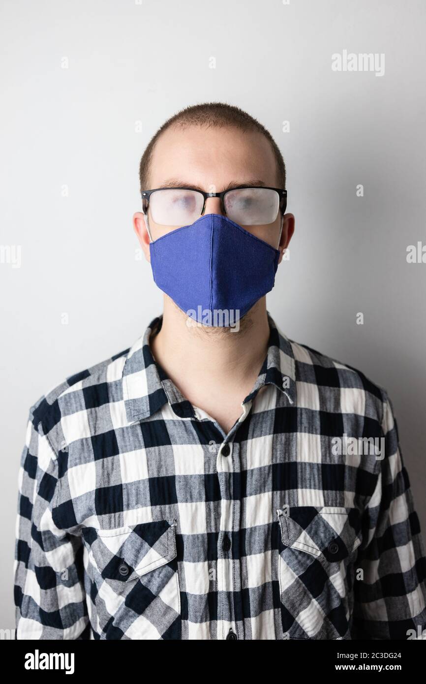 Homme portant un masque de protection et des lunettes à fogged. Nouvelles habitudes durant la pandémie de Covid-19. Le souffle chaud bouche les lunettes Banque D'Images
