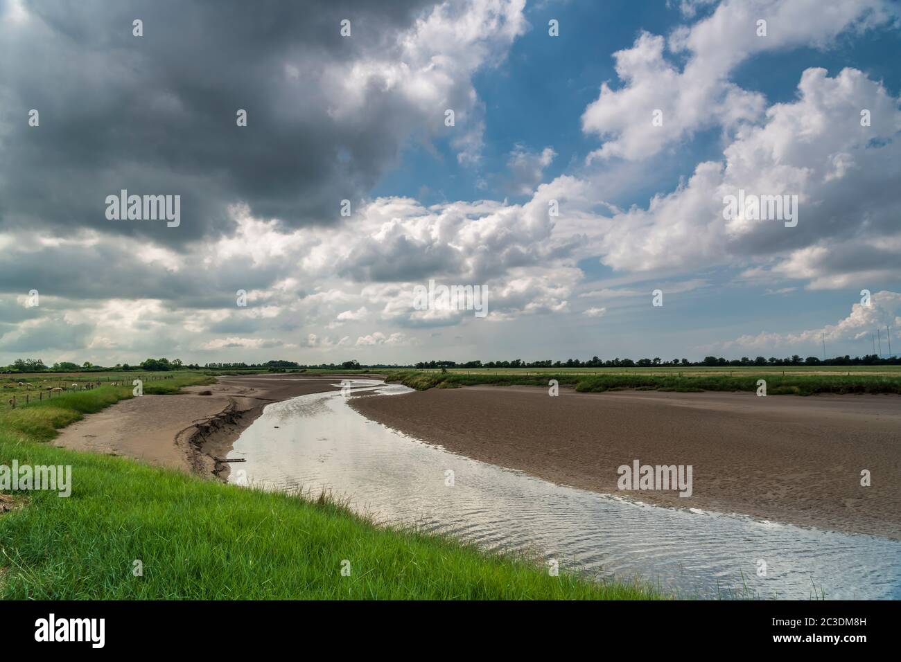 Un HDR de trois images nuageux, été, de la rivière Wampool dans le nord-ouest de Cumbria, Angleterre, à marée basse. 17 juin 2020 Banque D'Images
