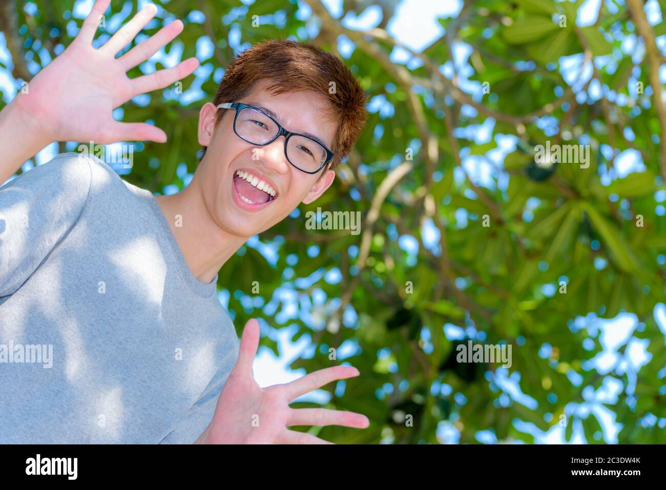 Asiatique amusant adolescent garçon portant des lunettes Banque D'Images