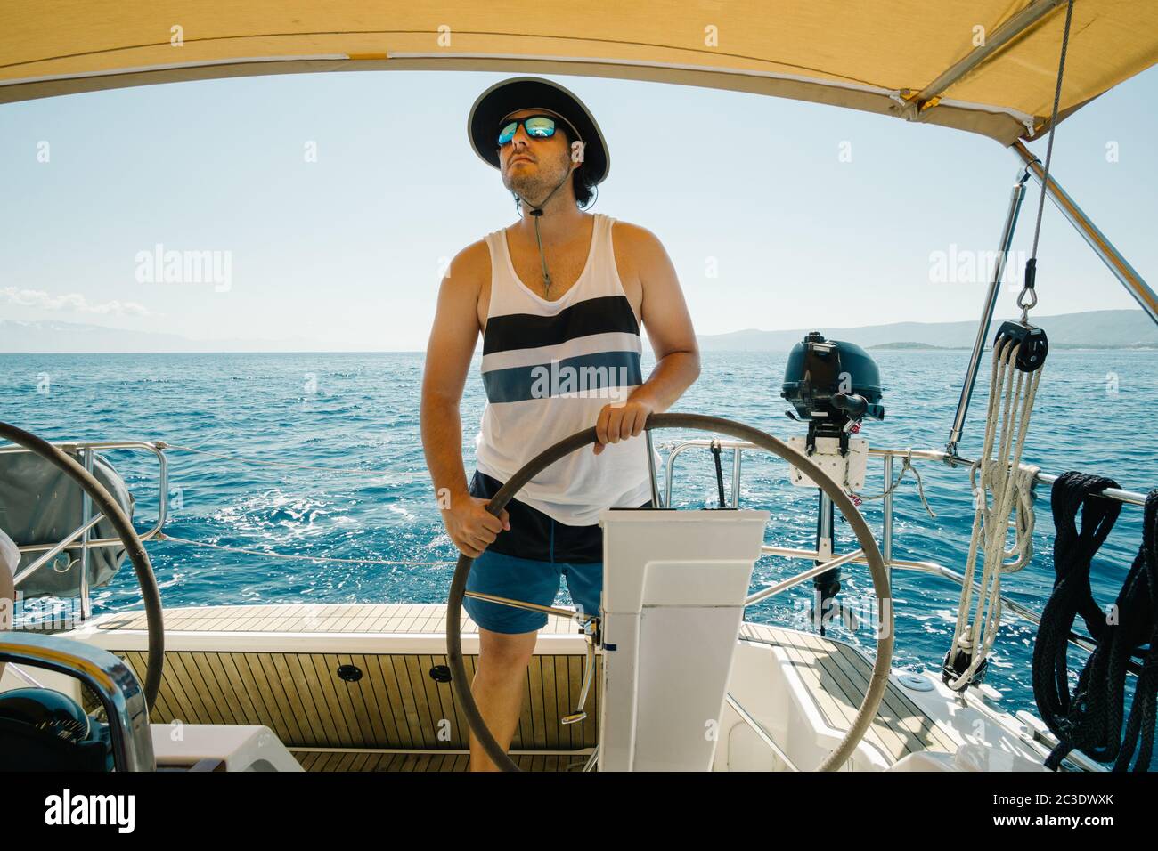 Skipper mâle sur le volant d'un yacht. Concept de voile et de yachting. Banque D'Images