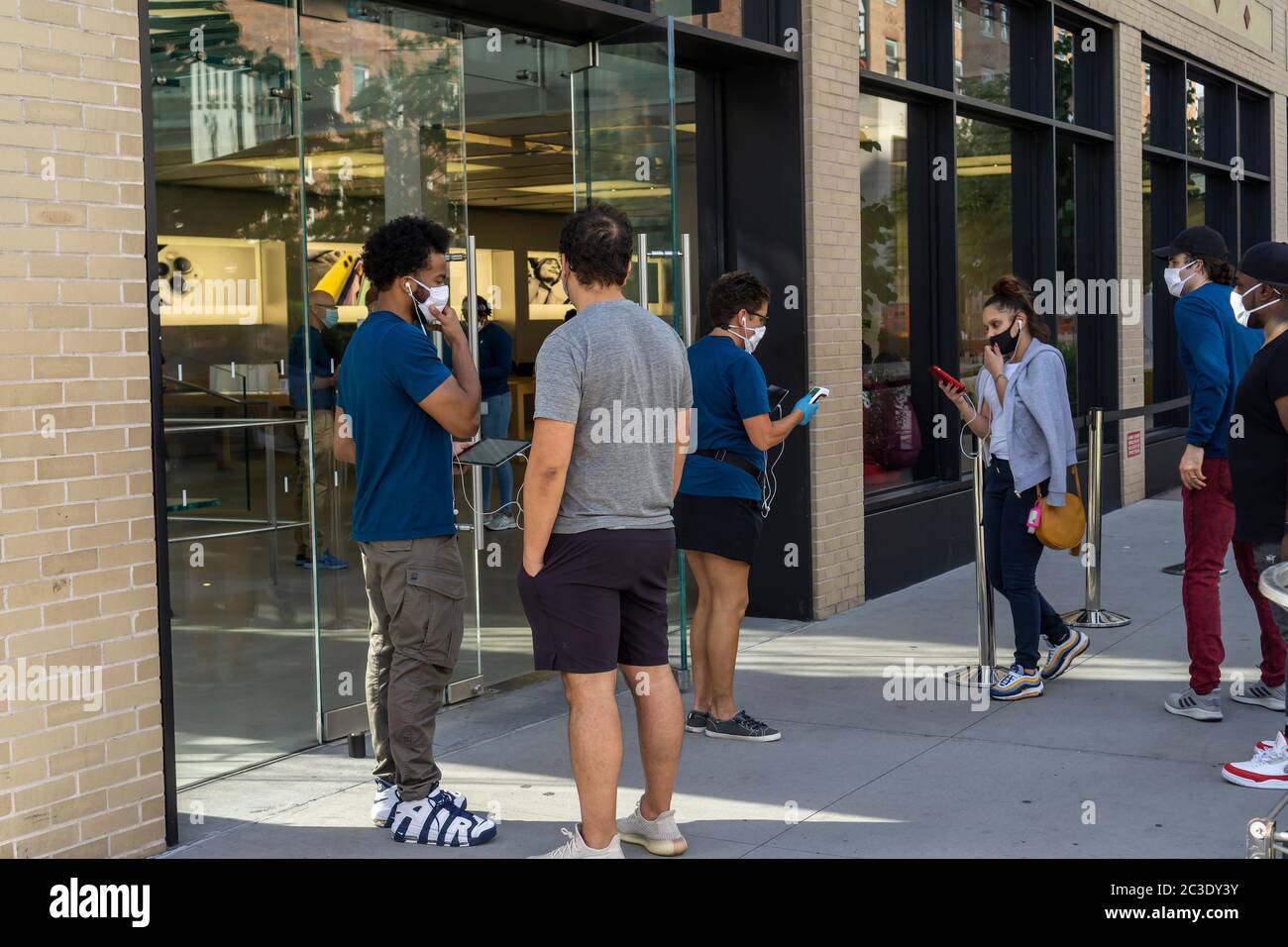 Clients et travailleurs à l'extérieur de la nouvelle boutique Apple, dans le quartier de Meatpacking à New York, le jeudi 18 juin 2020. Les magasins ont un personnel de nettoyage dédié et sont approvisionnés en masques, assainisseurs et iPhones, (© Richard B. Levine) Banque D'Images