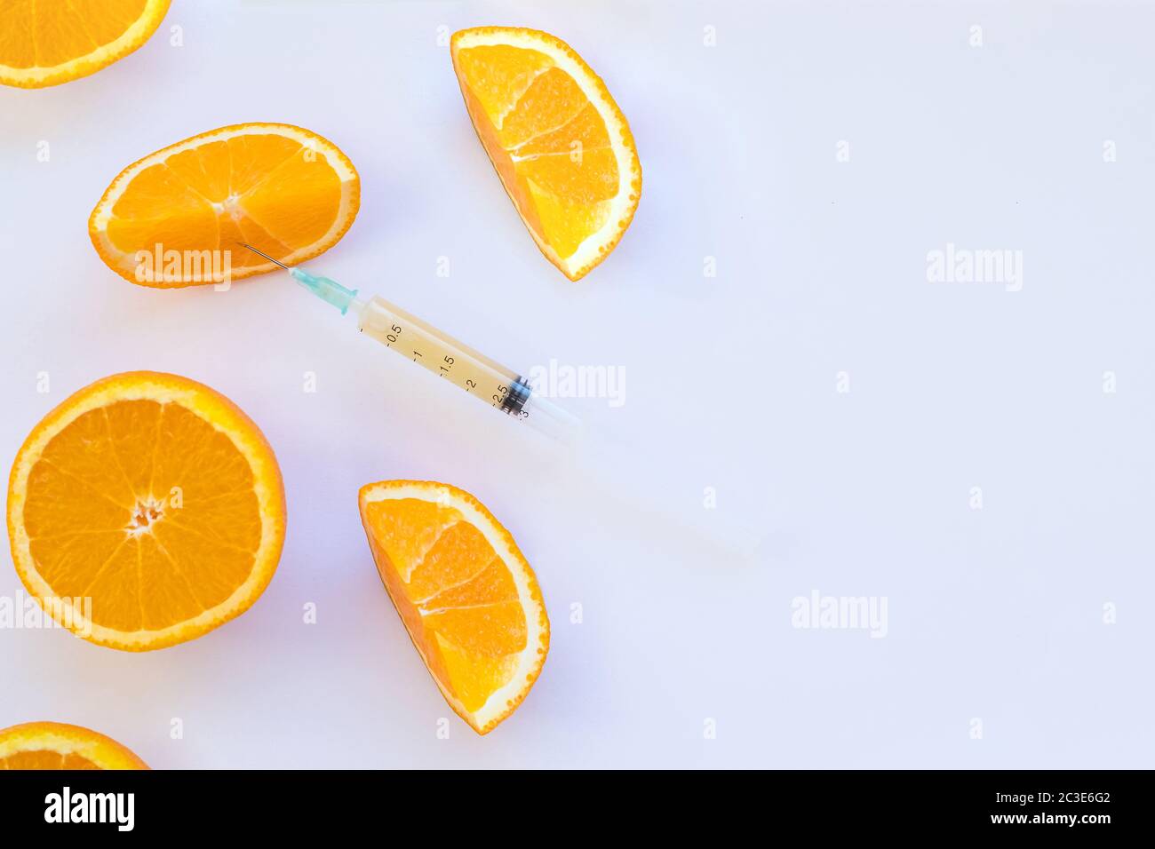 Atteindre pour la vitamine C. fruit mûr d'orange avec la seringue extraire liquide et montrant le concept de traitement de cellulite sur fond blanc.minéral Banque D'Images