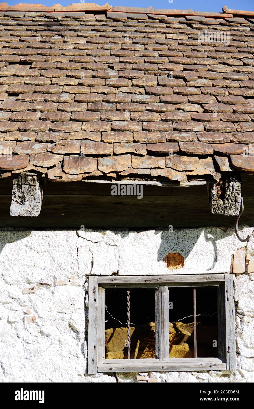 Grange en ruine avec fenêtre cassée et toit en tuiles endommagé Photo ...