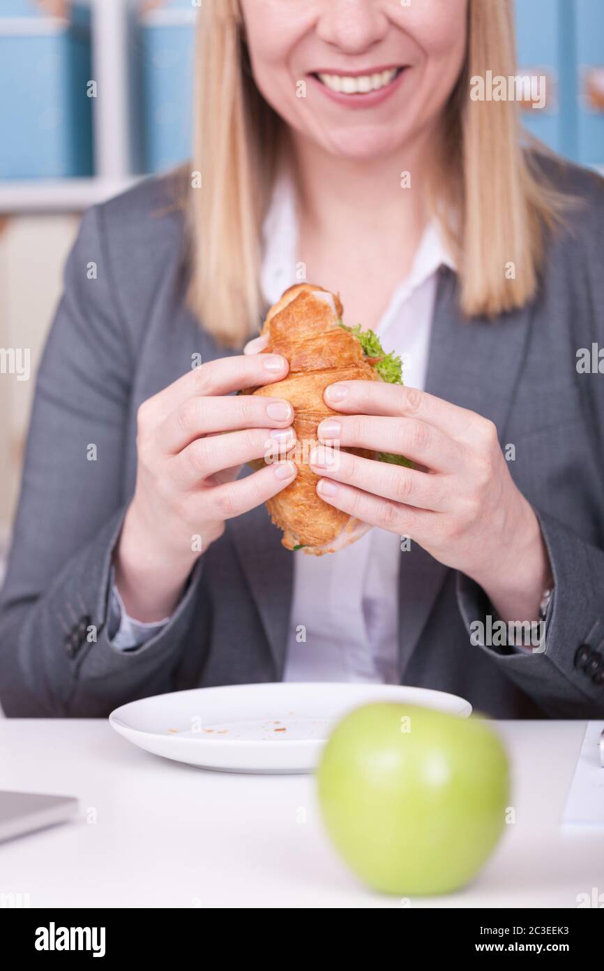 Femme au bureau manger de la nourriture dans sa pause. Concept d'affaires, de régime alimentaire et de mode de vie sain. Banque D'Images