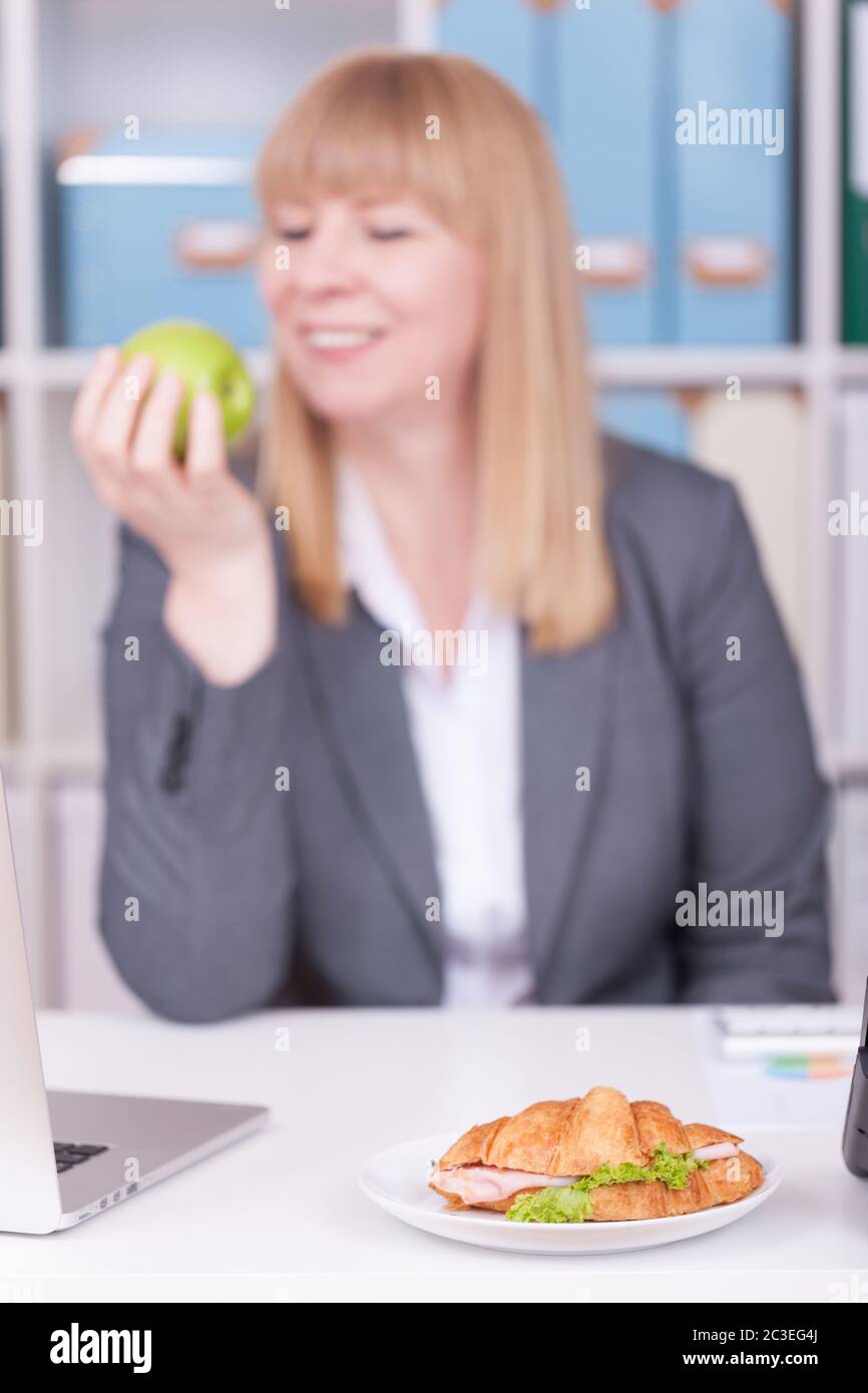 Femme au bureau manger de la nourriture dans sa pause. Concept d'affaires, de régime alimentaire et de mode de vie sain. Banque D'Images