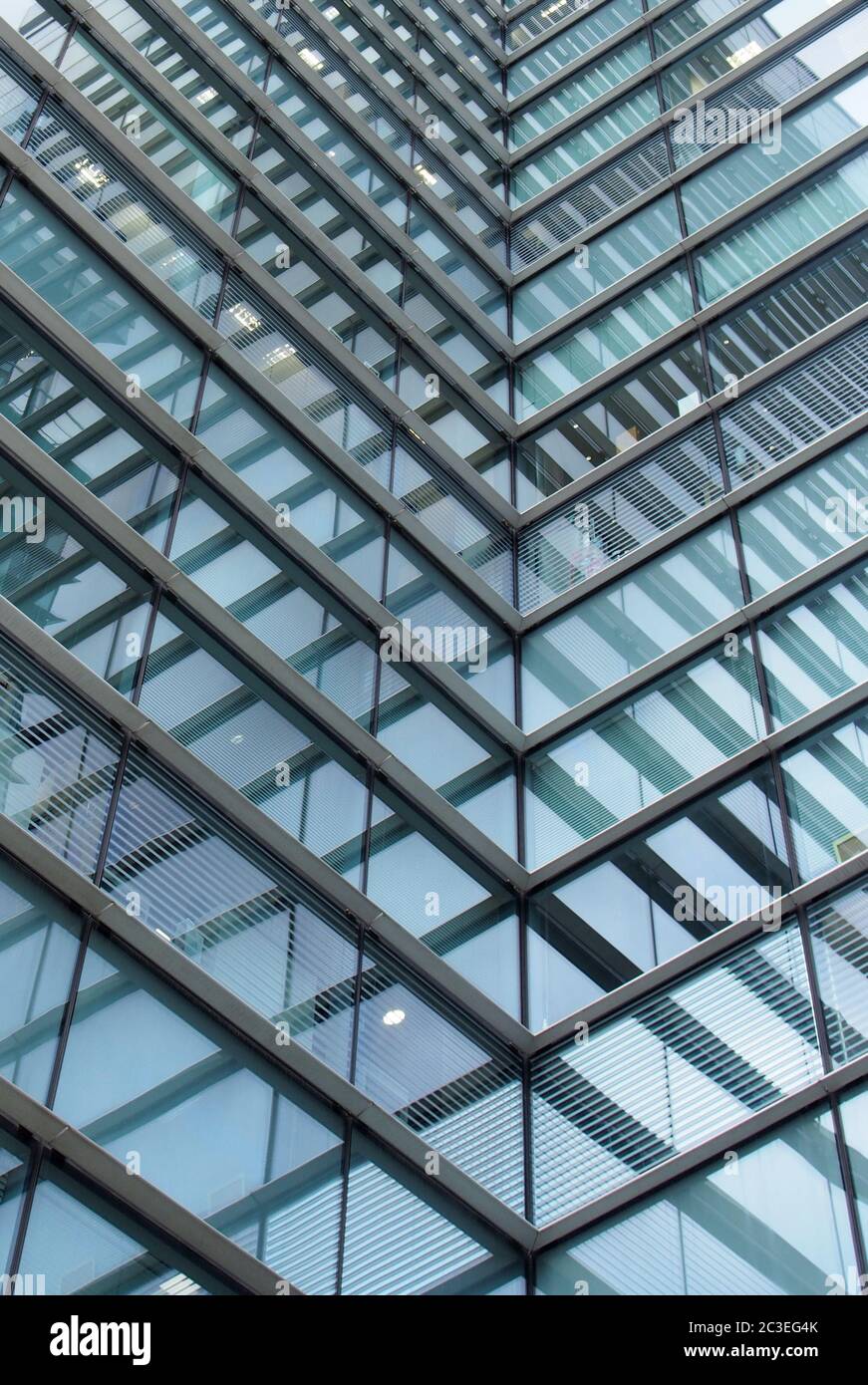 un cadre plein d'architecture moderne de bureau abstrait avec des formes géométriques angulaires reflétées et des lignes dans des fenêtres en verre bleu Banque D'Images