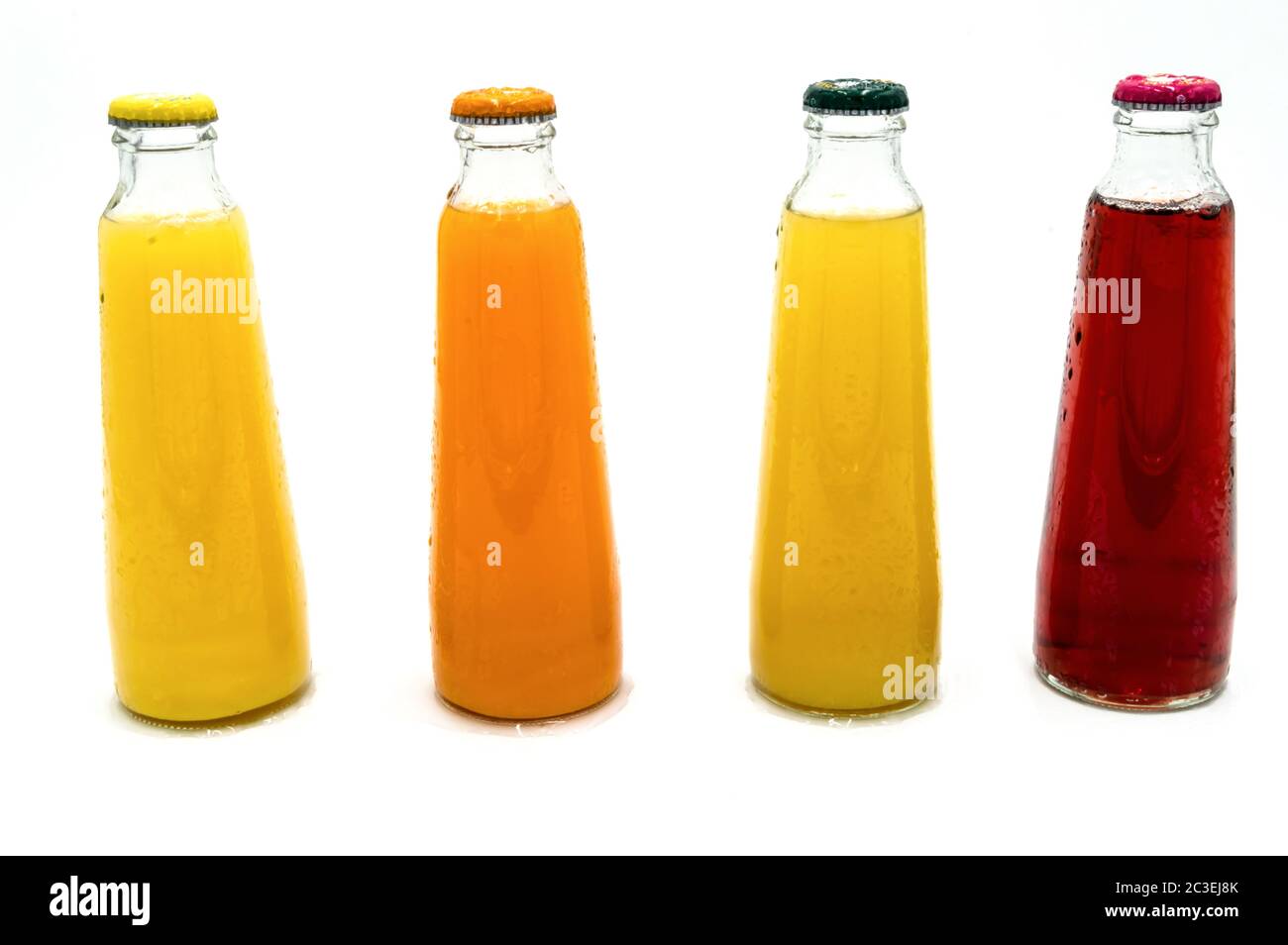 Quatre bouteilles de jus de fruits, cerise, orange, ananas Banque D'Images