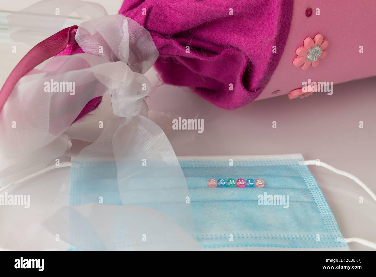 gros plan d'un masque avec le mot allemand Schule, signifie école, avec un cône rose dans le fond Banque D'Images