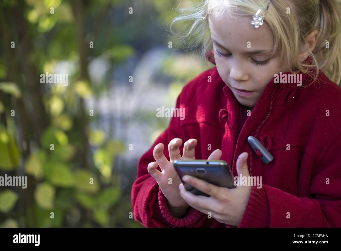 Fille (7) utilisant un smartphone, Kiel, Schleswig-Holstein, Allemagne Banque D'Images