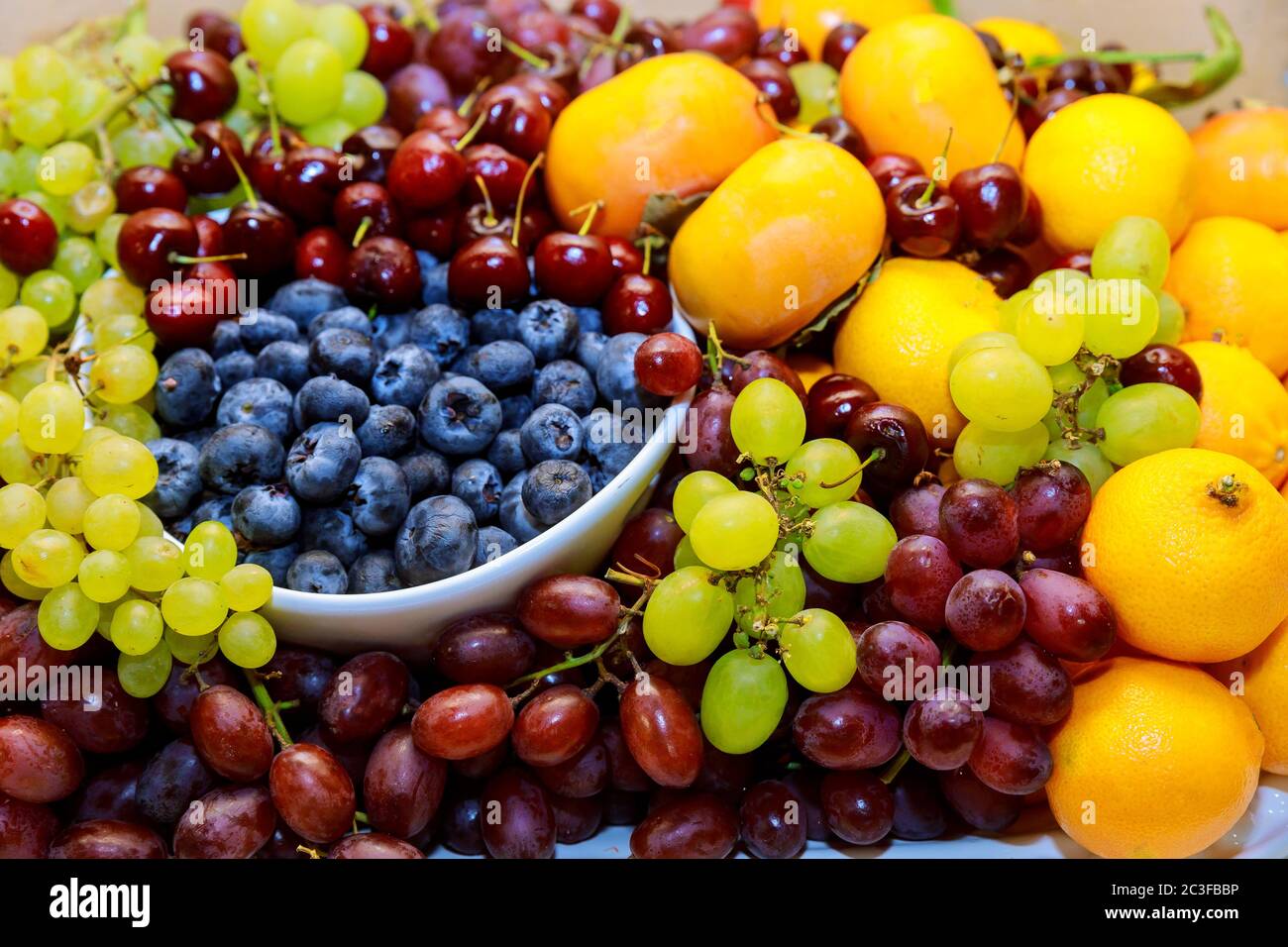Fruits frais biologiques, bleuets, raisins rouges et verts et mandarines. Gros plan. Banque D'Images