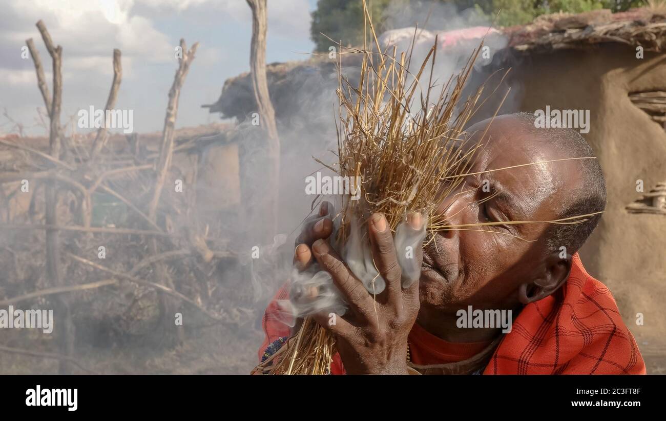 un guerrier de maasai commence à tirer de la manière traditionnelle à une manyatta au kenya Banque D'Images