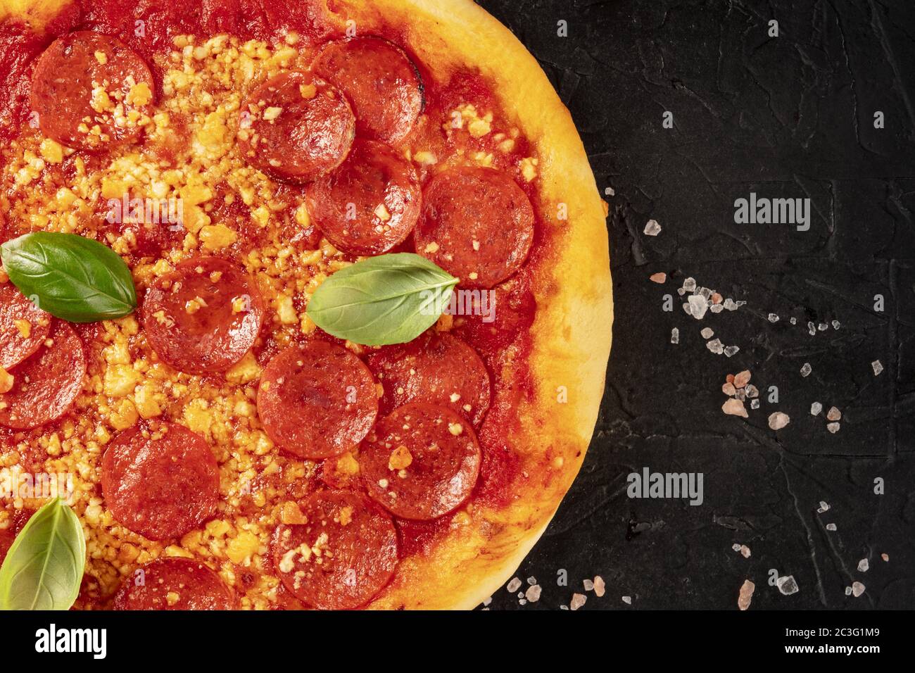Pizza pepperoni gros plan sur fond noir, tourné du haut avec un endroit pour le texte Banque D'Images