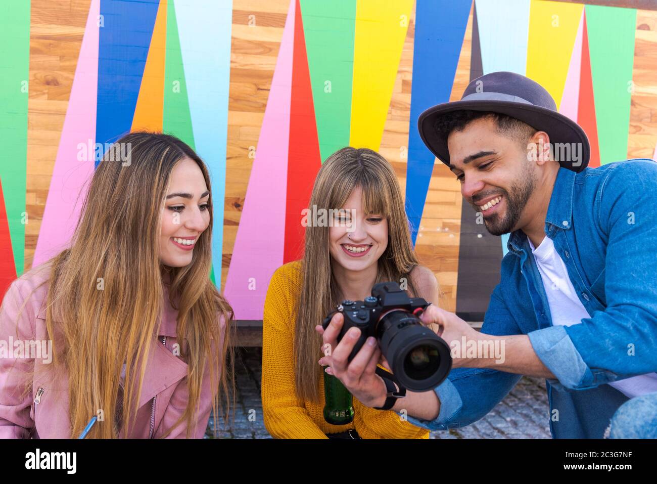 Un photographe sourit alors qu'il lui montre une photo de deux filles souriantes Banque D'Images