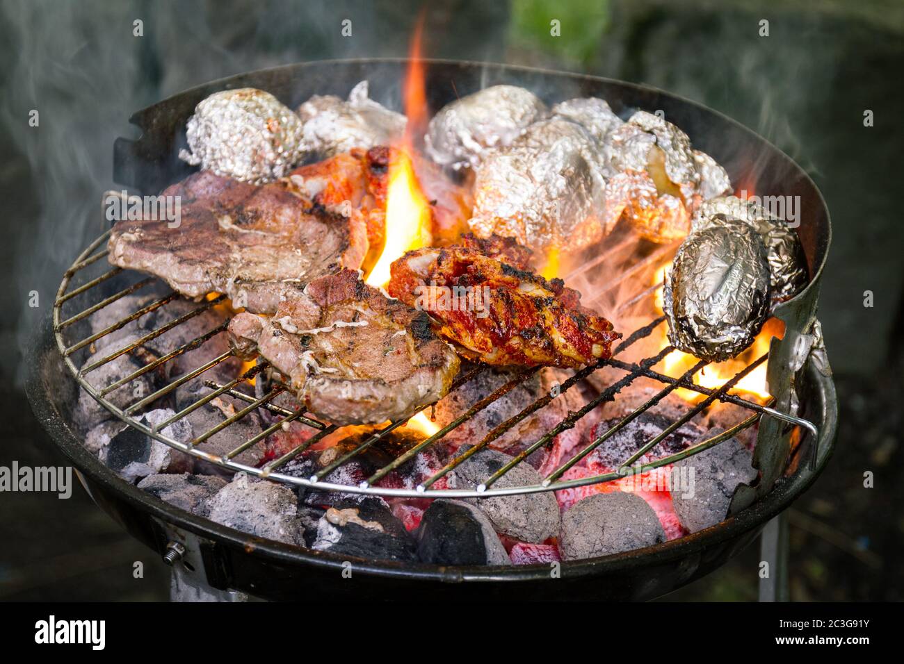 La viande fraîche de boeuf savoureux appétissant sur le gril cuisson sur feu ouvert sur grill grille. Arrière-plan de la nature. Libre. Banque D'Images