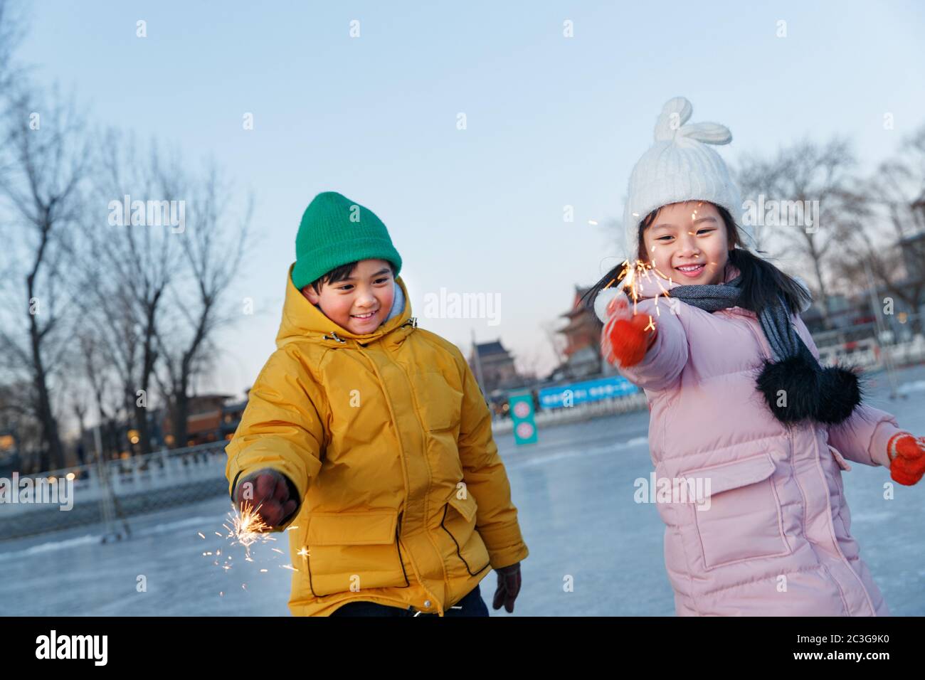 Les enfants sont heureux de faire du patinage sur la patinoire des feux d'artifice Banque D'Images