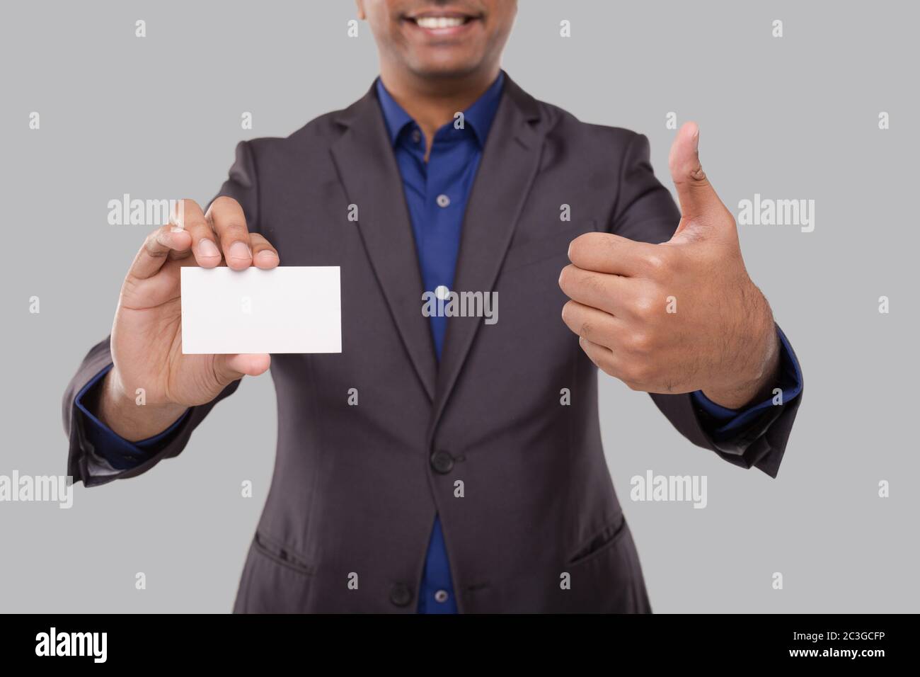 Homme d'affaires montrant la carte de visite et de pouce isolés gros plan. Carte vierge pour homme d'affaires indien en main Banque D'Images