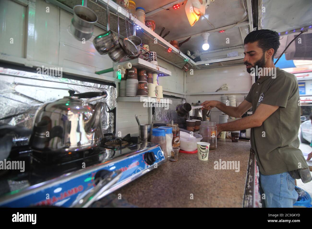 Gaza. 18 juin 2020. Shaaban Hamouda prépare du café sur un petit stand dans la ville de Rafah, dans le sud de la bande de Gaza, le 18 juin 2020. Shaaban Hamouda, un vendeur de café palestinien de la ville de Rafah, dans le sud de la bande de Gaza, est devenu l'une des rares personnes à avoir eu l'idée de livrer des boissons aux clients en vélo. POUR ALLER AVEC "Feature: Les jeunes ont mis en place des projets générateurs de revenus pour surmonter les difficultés dans la bande de Gaza" crédit: Khaled Omar/Xinhua/Alay Live News Banque D'Images