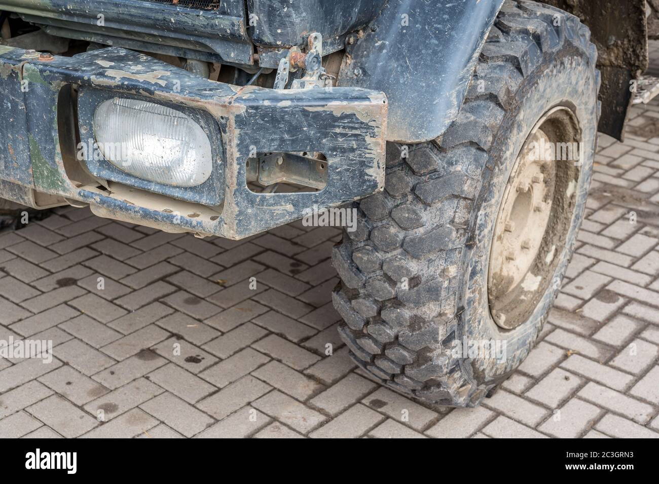 Image détaillée d'un camion rayé et sale avec pare-chocs et pneu avant Banque D'Images