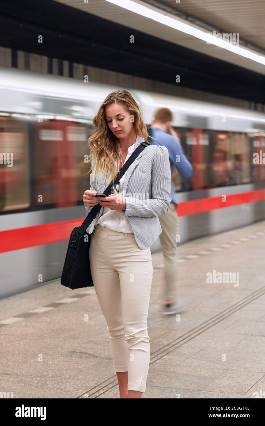 Jeune femme d'affaires attendant le métro dans le métro.Voyager au travail. Banque D'Images