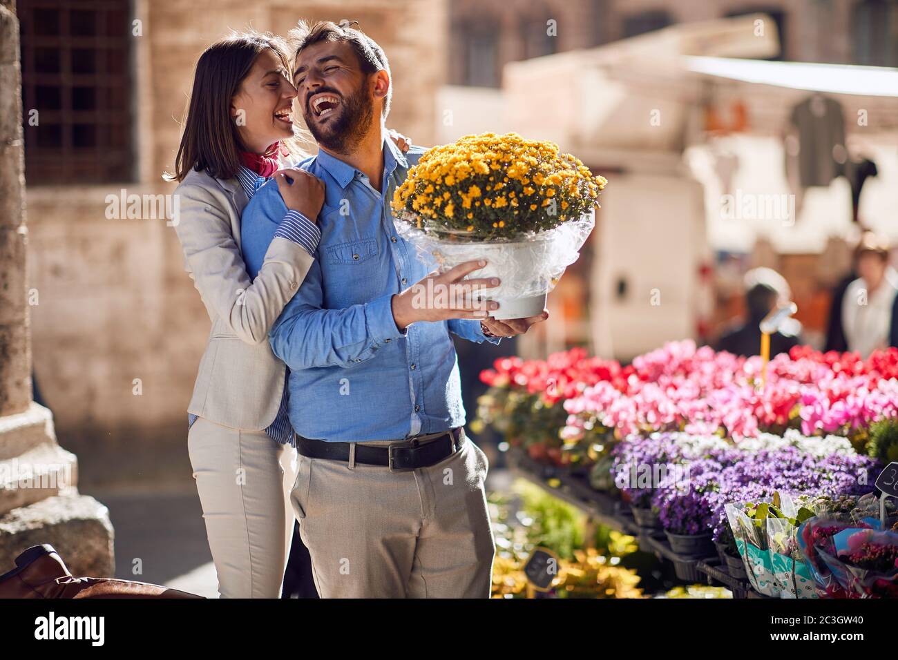 jeune couple de caucasiens heureux dans leur lune de miel en italie, toscane, europe. L'homme achète un seau de fleurs pour sa petite amie Banque D'Images