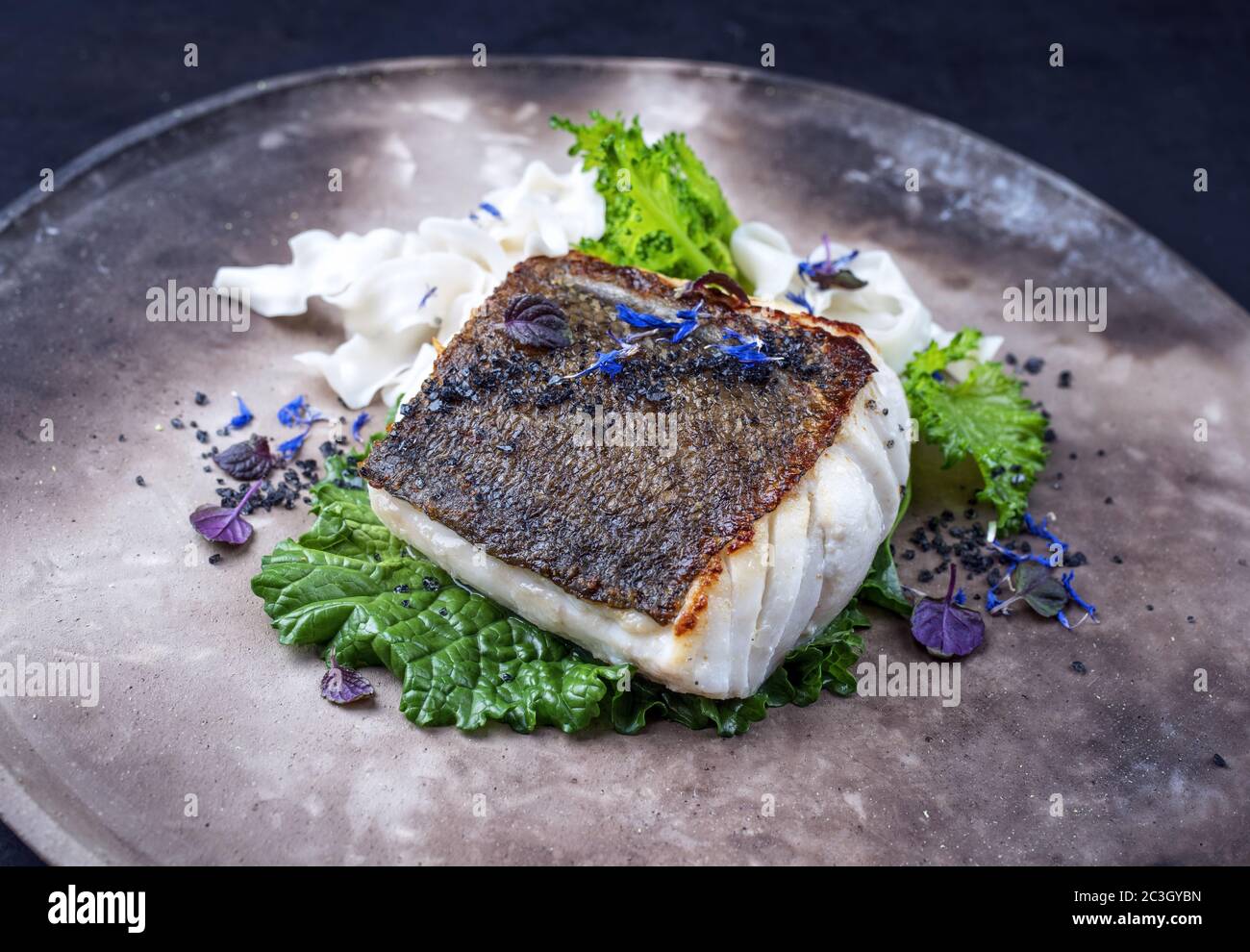 Filet de morue poêlé gastronomique de brocoli rabe et nouilles rabei sur une assiette moderne Banque D'Images