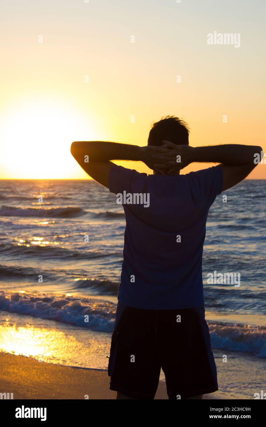 Les mains des jeunes se détendent au lever du soleil sur un fond de ciel bleu et de mer, horizon plage aube Banque D'Images