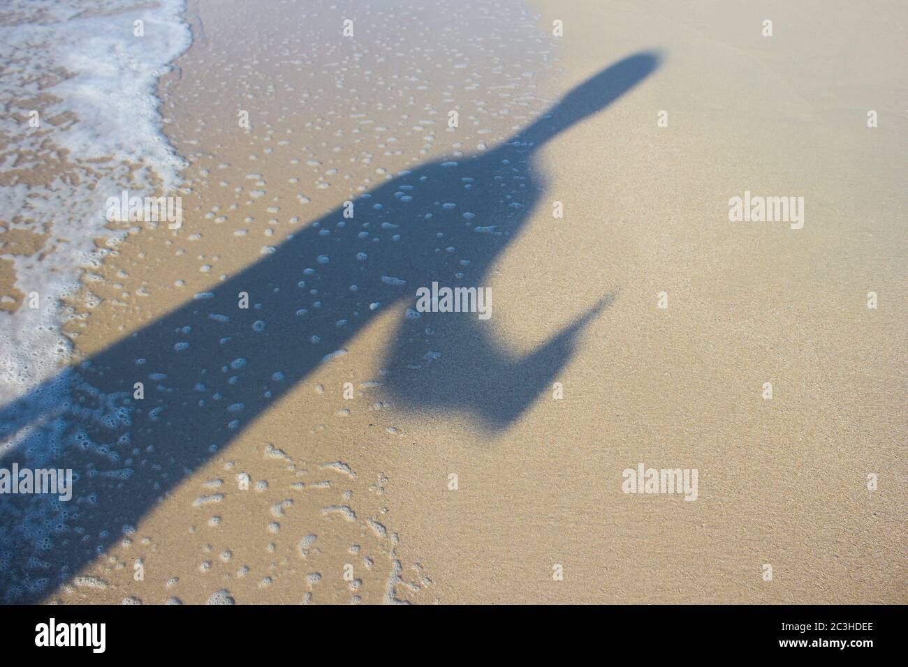 Ombre d'un jeune homme avec ses mains au lever du soleil sur le fond de la mer, l'horizon plage lever du soleil Banque D'Images
