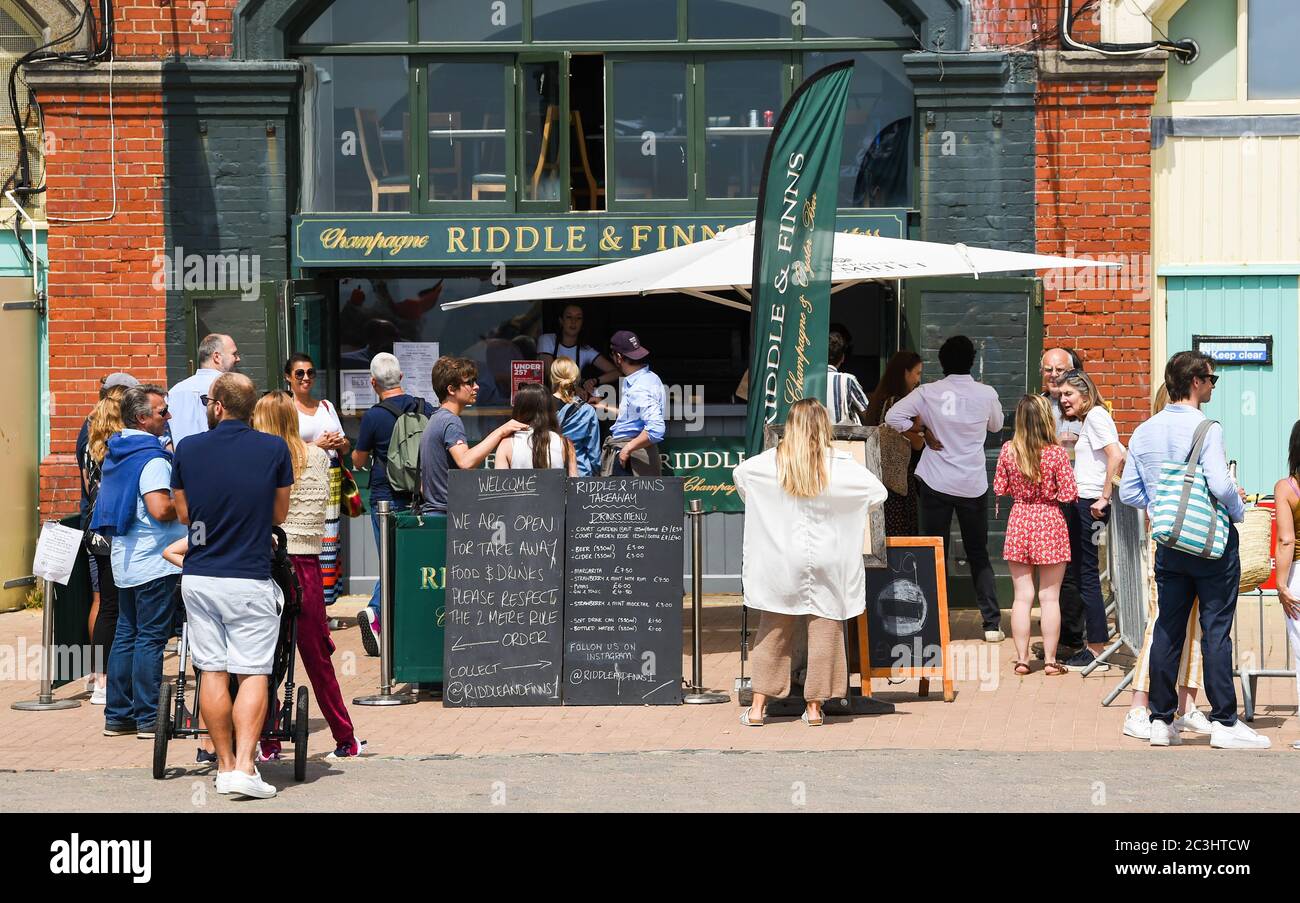 Brighton, Royaume-Uni, 20 juin 2020 - les visiteurs font la queue pour manger et boire au bar Riddle & Finns Seafood, par temps chaud et ensoleillé sur le front de mer de Brighton, aujourd'hui, les restrictions de verrouillage étant progressivement assouplies en Angleterre pendant la crise pandémique du coronavirus COVID-19 . : crédit Simon Dack / Alamy Live News Banque D'Images