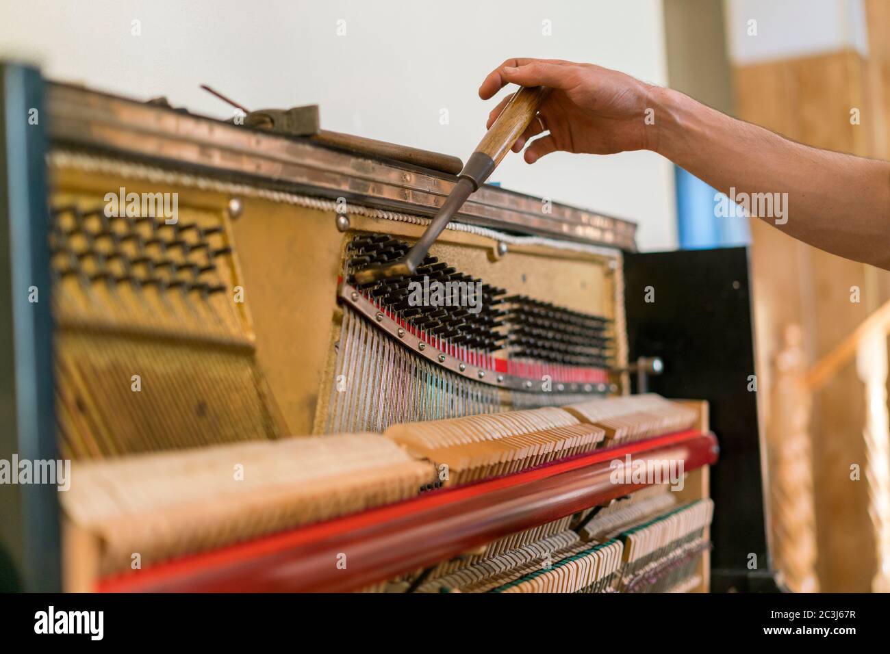 Processus de réglage du piano. gros plan de la main et des outils de tuner travaillant sur le piano à queue. Vue détaillée du piano droit pendant un réglage Banque D'Images