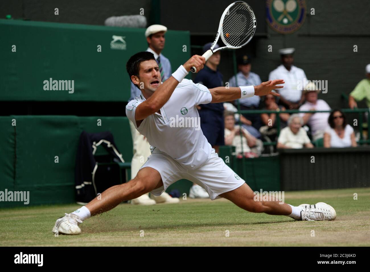 Novak Djokovic s'étend pour un avant-main lors de son match de demi-finale contre Tomas Berdych à Wimbledon. Banque D'Images