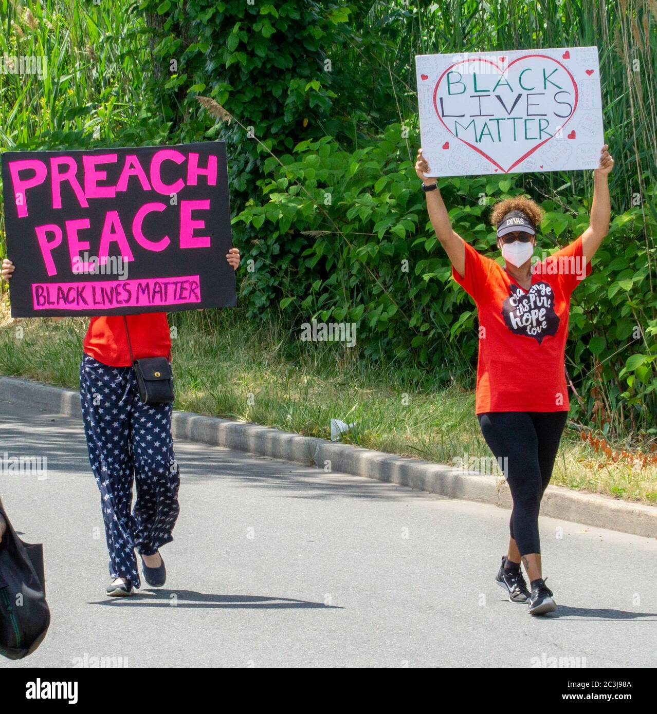 Le dix-septième mars, des vies noires comptent protester George Floyd - deux femmes protestant contre la présence de panneaux DE PAIX portant des chemises orange Banque D'Images
