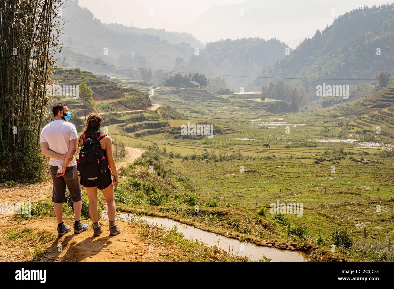 De jeunes touristes qui font de la randonnée à Sapa (sa Pa), au Vietnam, tout en portant des masques chirurgicaux pendant la pandémie de coronavirus Covid-19 Banque D'Images