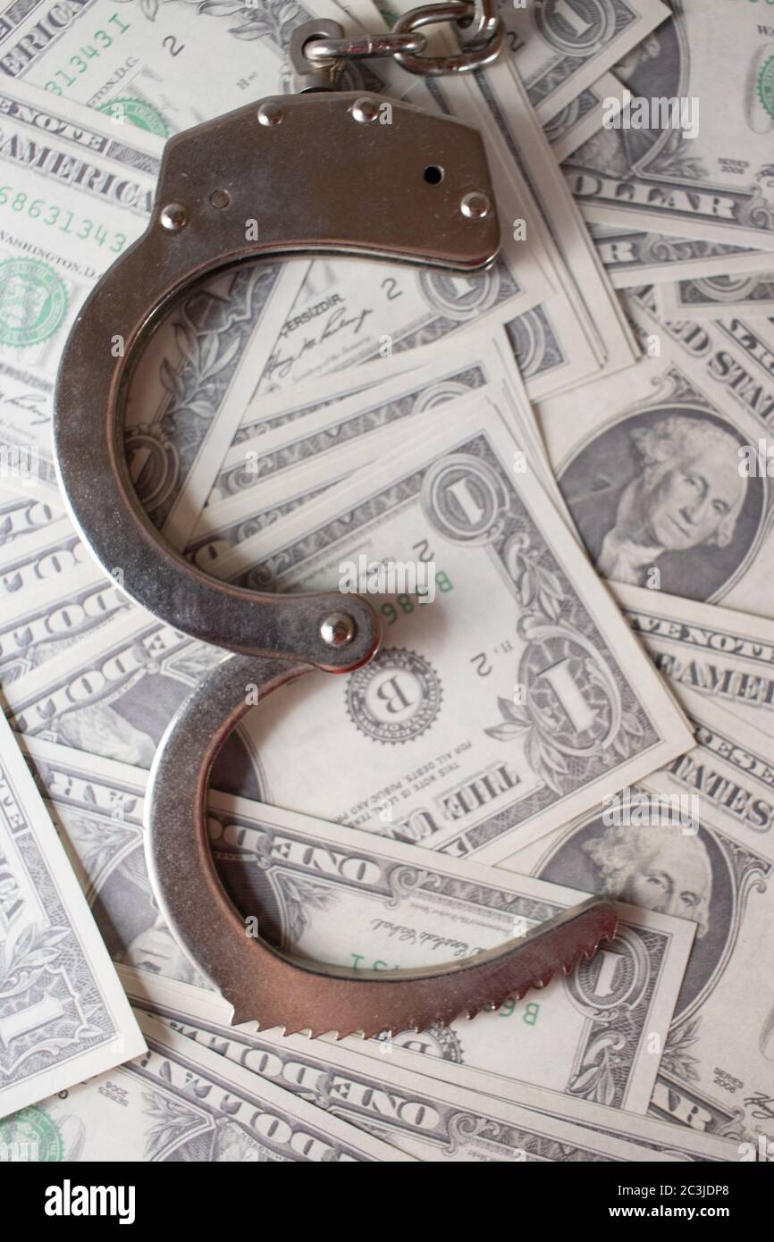 Plan vertical à grand angle des menottes sur un tas de des billets d'un dollar Banque D'Images