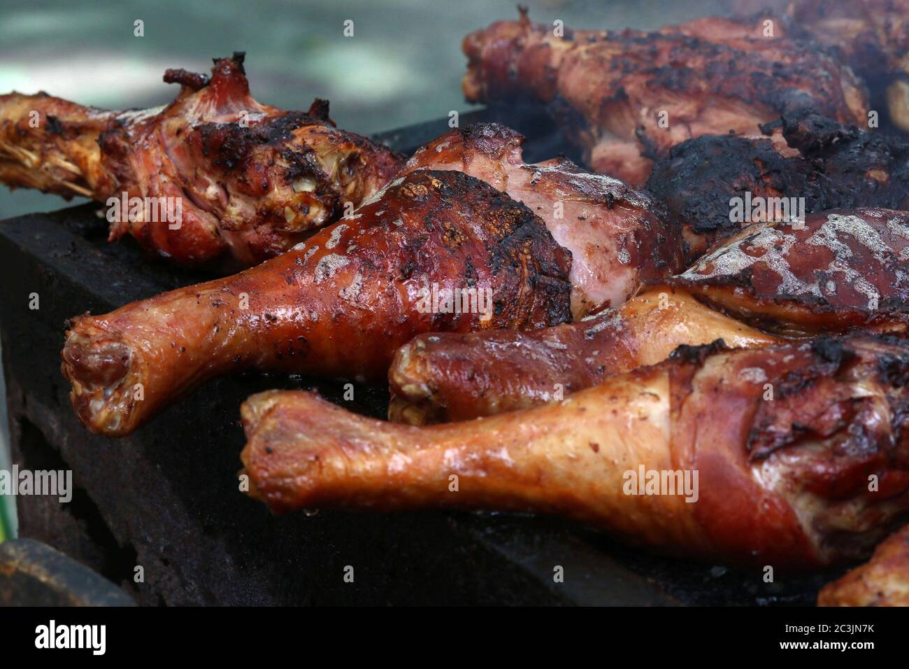 Des pilons de dinde grillées sur un grill à la foire de rue Banque D'Images