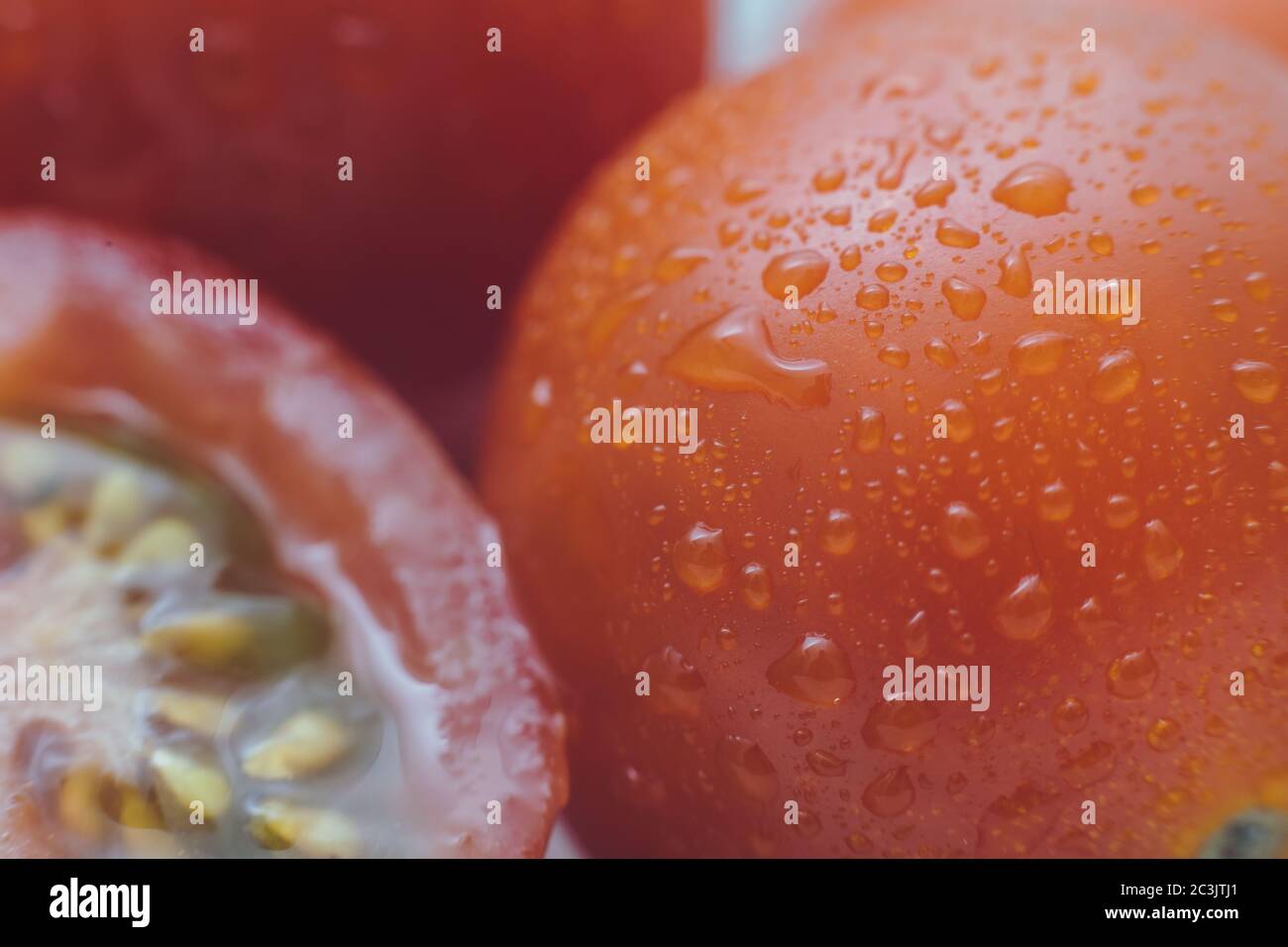 Photo macro de tomates fraîches. De l'eau coule sur de délicieux légumes Banque D'Images