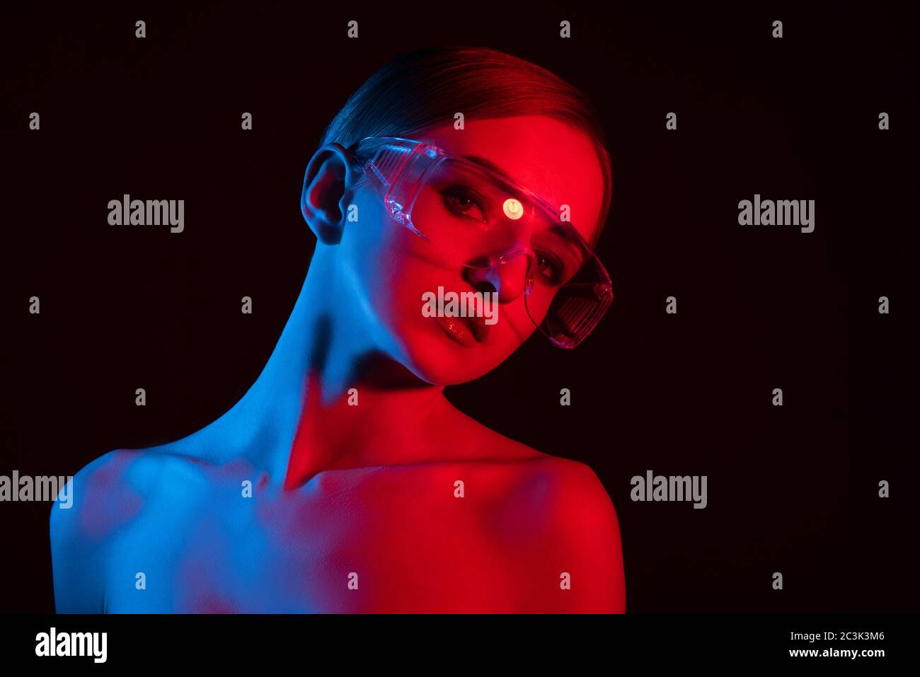 portrait de fille en lunettes de style disco avec lumière bleue et rouge, fille avec les grands yeux et peau lisse, Banque D'Images