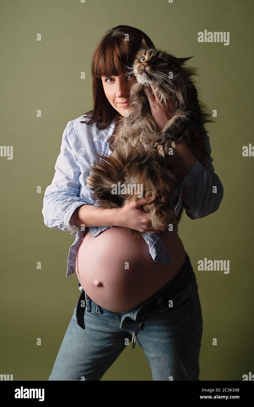 La Jeune Femme Enceinte Tient Le Gros Chat Dans Ses Bras Le Gros Ventre Nu Depasse Photo Stock Alamy