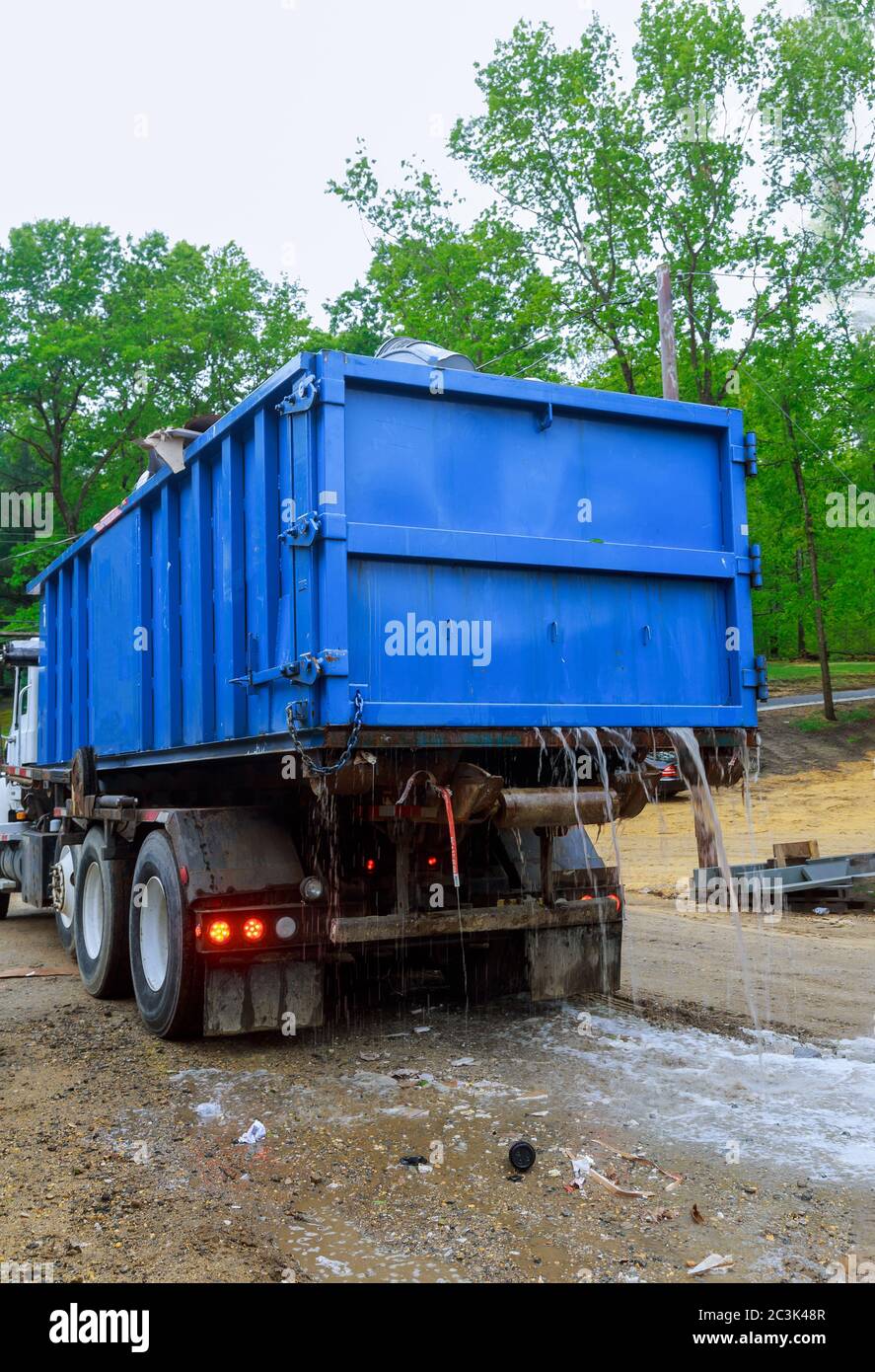 La benne chargée près d'un conteneur métallique sans couvercle est pleine de déchets de construction dans le bâtiment en cours de construction Banque D'Images