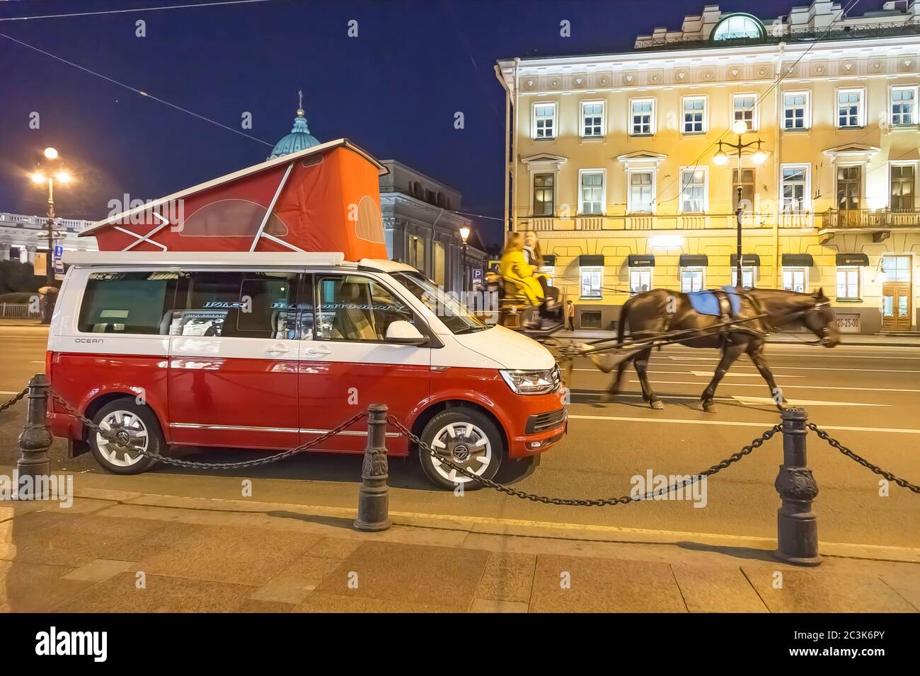 Saint-Pétersbourg, Russie - 22 juillet 2019 : Volkswagen Multivan California Ocean (transporteur T6), de couleur rouge et blanc. Est garée dans la rue près de la cathédrale de Kazan. Les chevaux marchent Banque D'Images