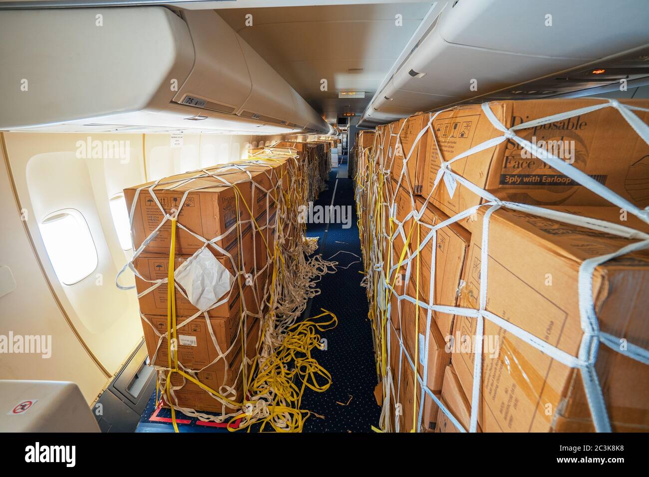 Vue intérieure d'un passager converti en avion cargo chargé Avec des boîtes de masques chirurgicaux et robes de Chine à Combattre la pandémie de COVID Banque D'Images