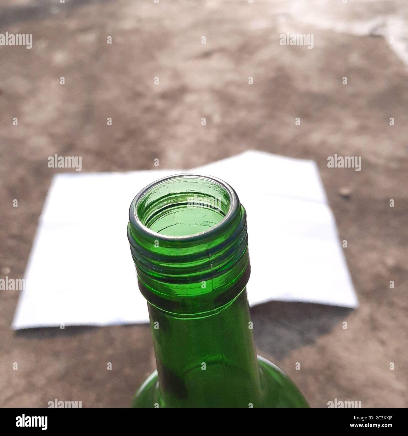 gros plan de la bouteille en verre, sur l'arrière-plan comme portrait du ciel du lever du soleil, mur. Banque D'Images