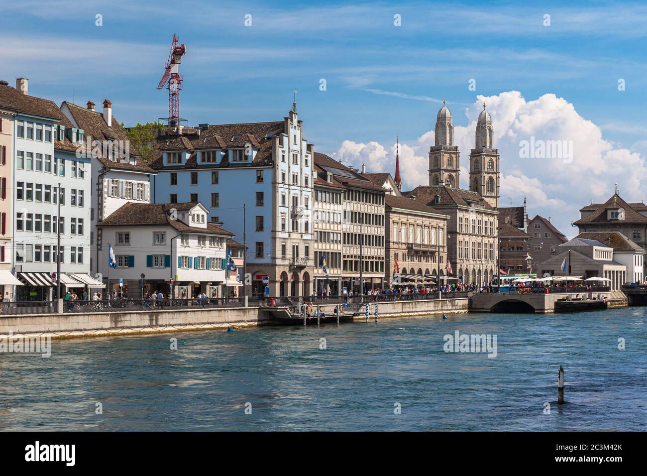 Beau quartier commerçant de Limmatquai dans le centre de Zurich sur le côté de la rivière Limmat lors d'une journée ensoleillée d'été avec l'église Grossmuenster et ciel bleu nuage i Banque D'Images